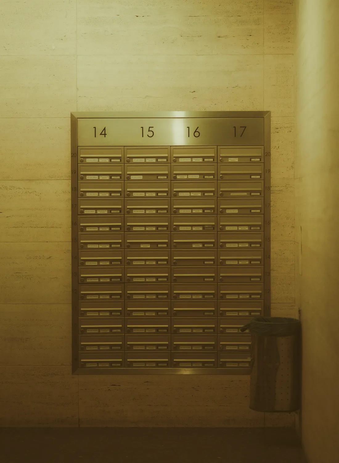Briefkastenanlage aus Edelstahl in einem Hausflur, nur Hausnummern zu sehen