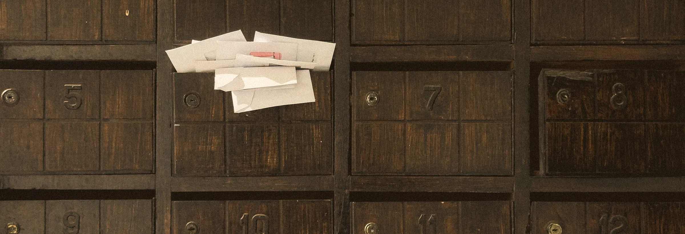 Alte Holz-Postfächer mit eingesteckten Briefen