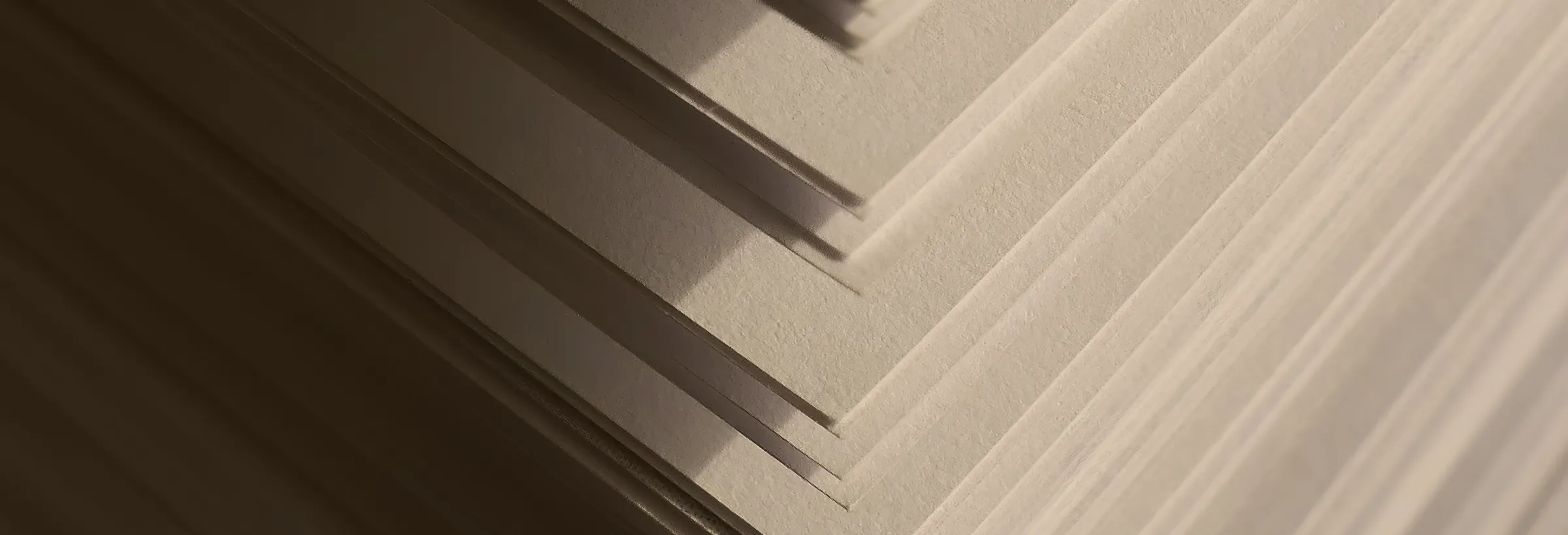 Kante eines Papierstapels mit hartem Schattenwurf