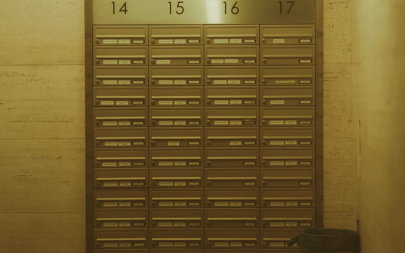 Briefkastenanlage aus Edelstahl in einem Hausflur, nur Hausnummern zu sehen