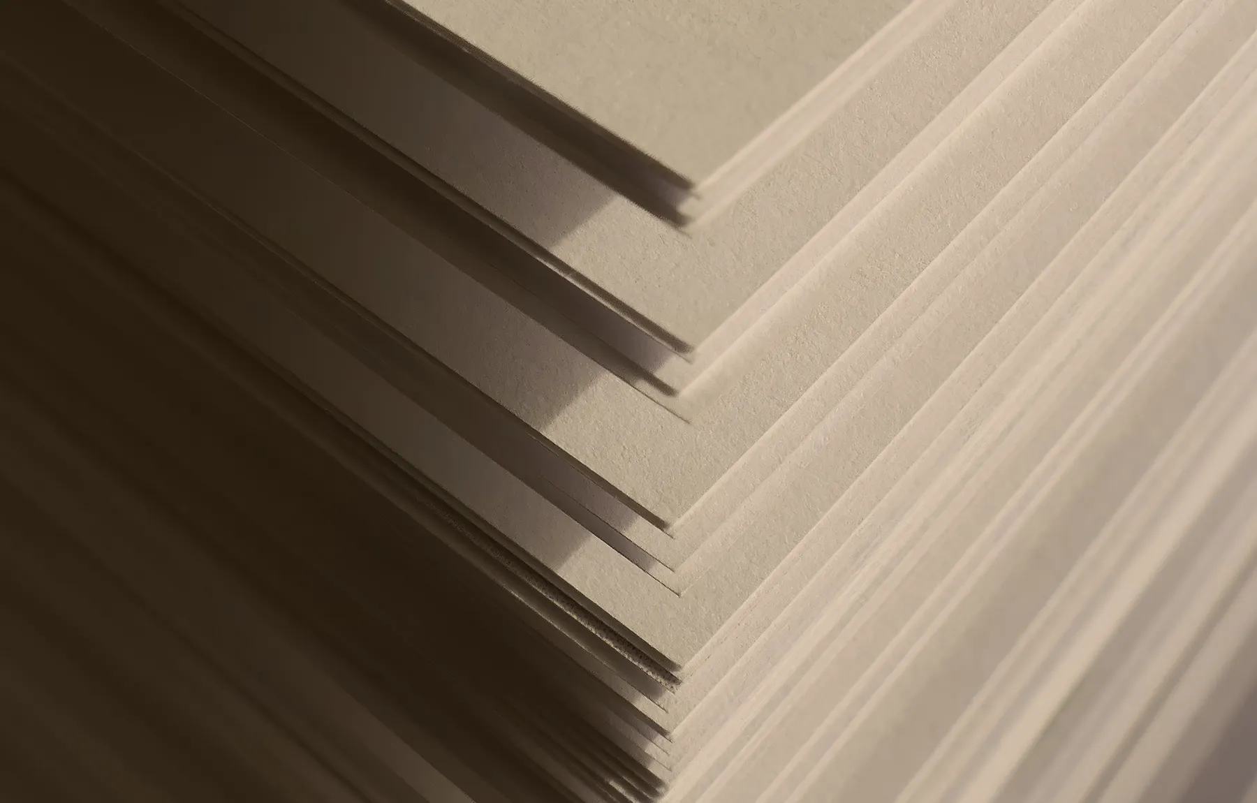Kante eines Papierstapels mit hartem Schattenwurf